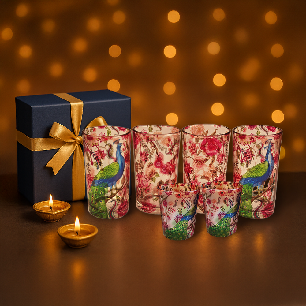 Set of floral-patterned candles with a gift box against a warm, blurred background